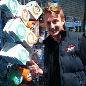 JTAPE employee stood next to products