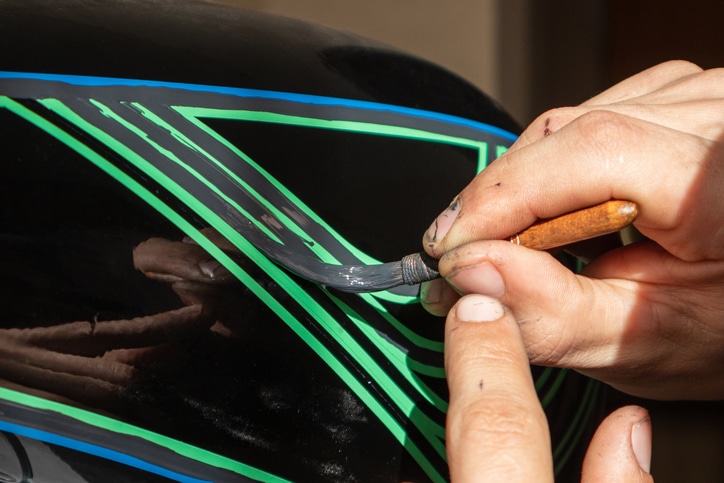 the artist creating the pinstriping image with a special brush