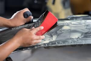 Closeup of hand sanding car bumper