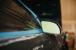 A car window and wind-mirror with masking tape