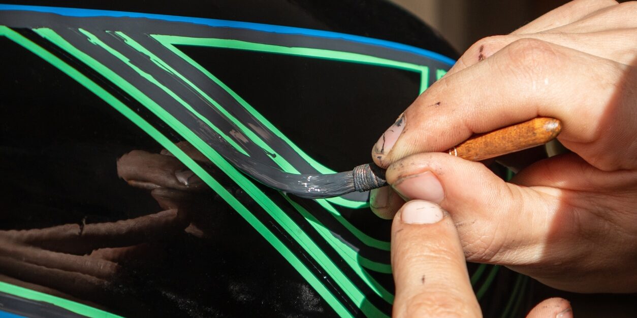 Close up of a man painting using tape