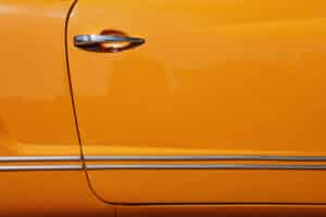close up of an orange car with a silver handle