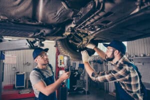 2 mechanics working under a car