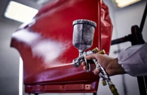 Painting the car door in red color in the painting chamber.