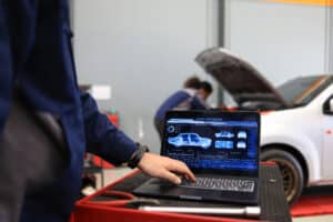 Mechanical engineer check and maintenance, smart maintenance system in modern car garage. Auto mechanic work with smart software maintenance vehicle
