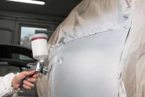 Painter spray gun in the hands of a painter.