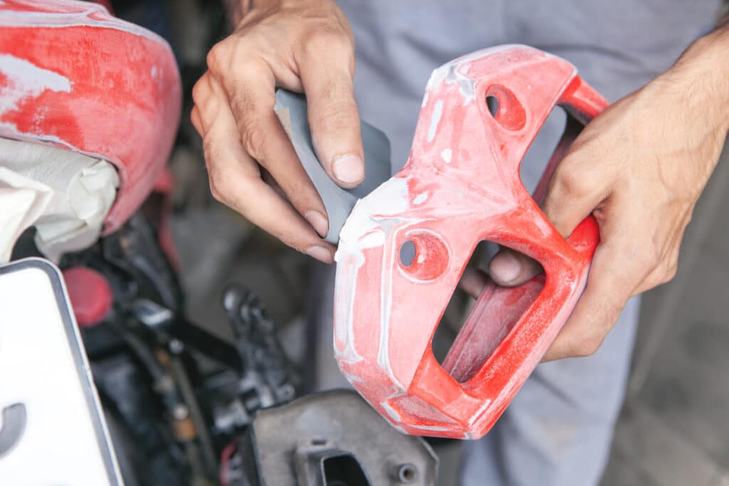 Cropped mans hands holding a red sander