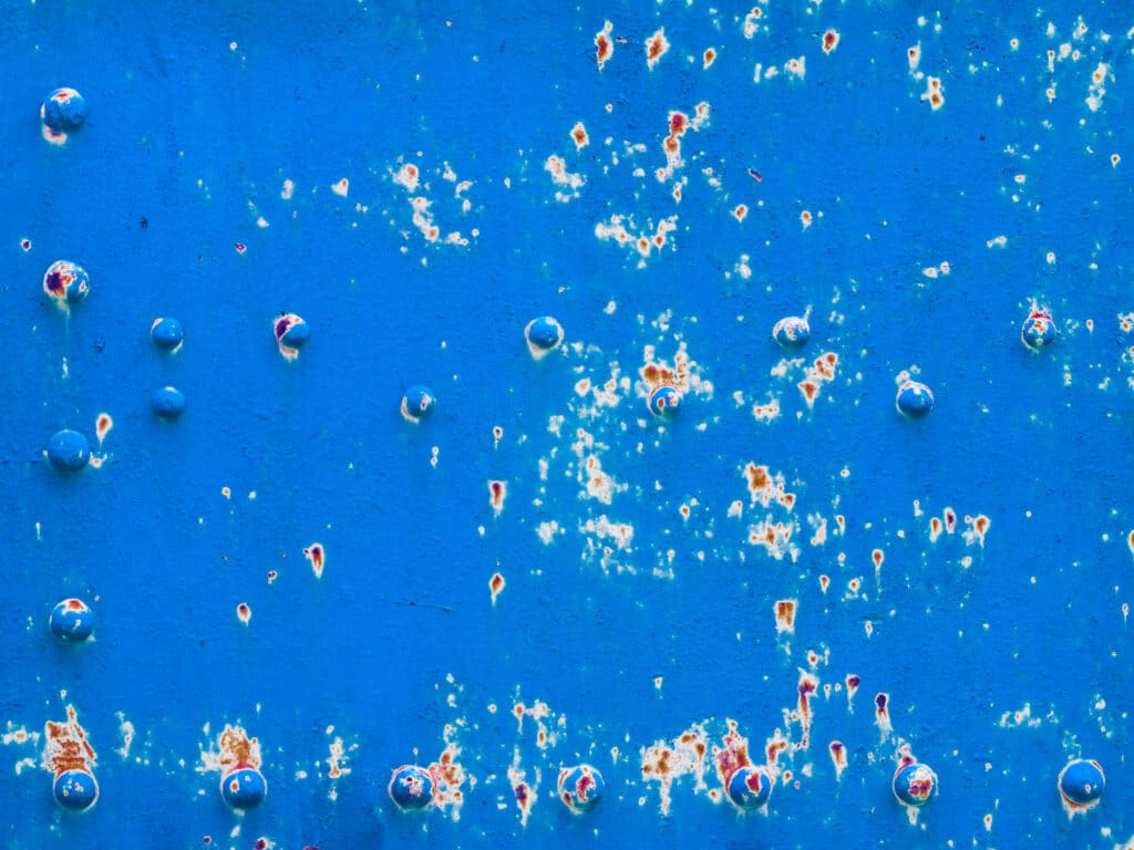 Small splatters of paint cratering on blue paint