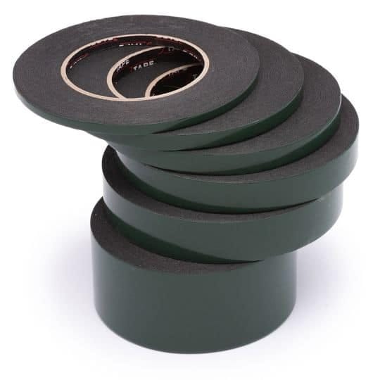 A stack of green tape of different widths, on a white background