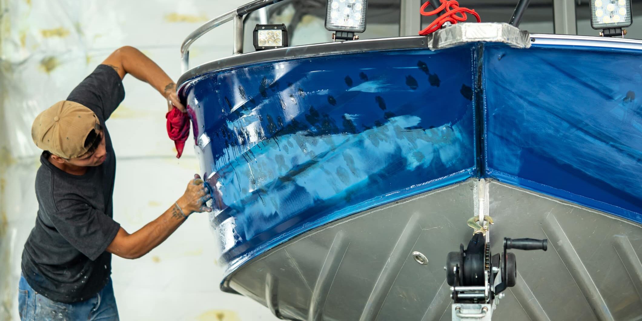 Repairing boat body by puttying close up work after the accident by working sanding primer before painting. , The mechanic repair the boat , Using plastic putty ,Prepare surface for boat,