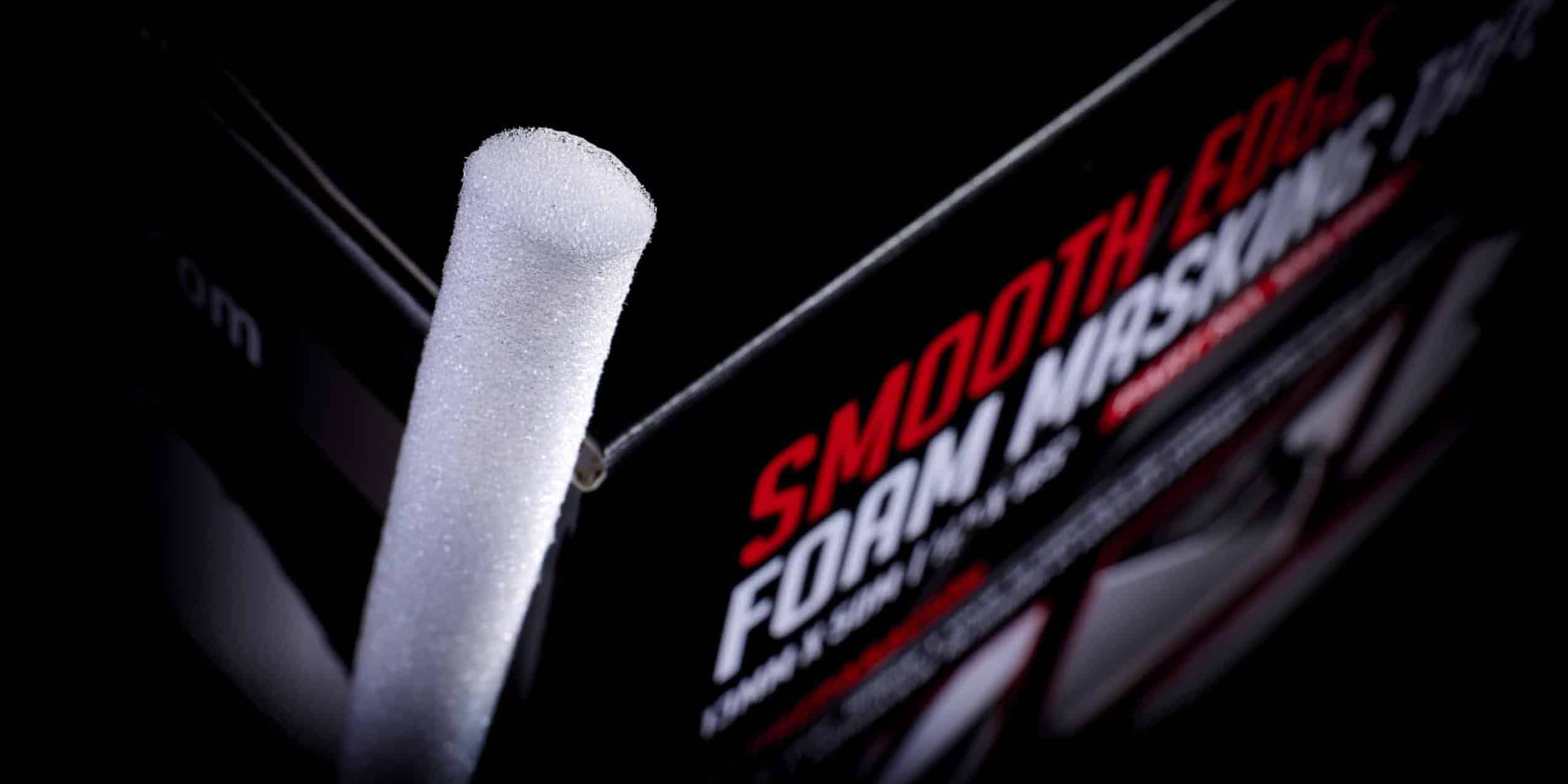 A close up image of the end of a piece of thin white foam tape next to a black box with the text "Smooth Edge Foam Masking" visible.